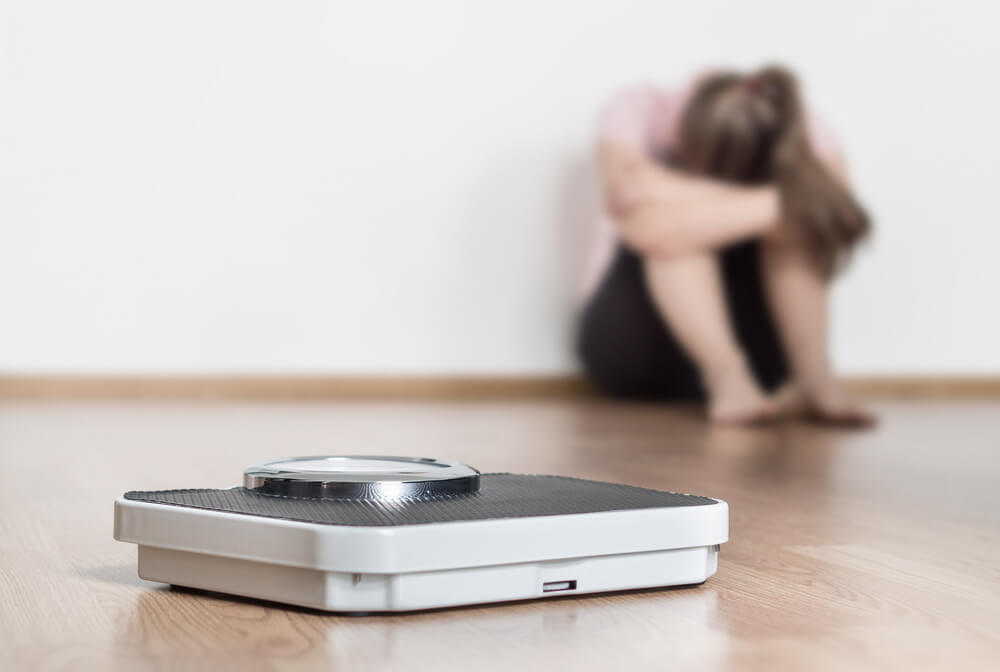 Une femme triste à côté d'une balance; 