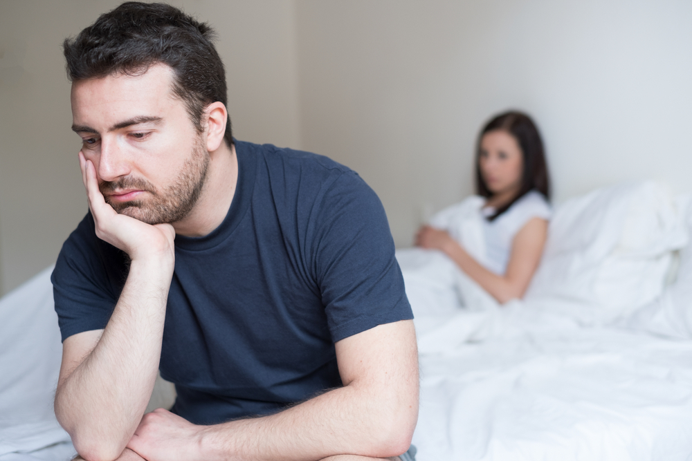 Un homme souffrant de dysfonction érectile dans son lit avec sa femme. 