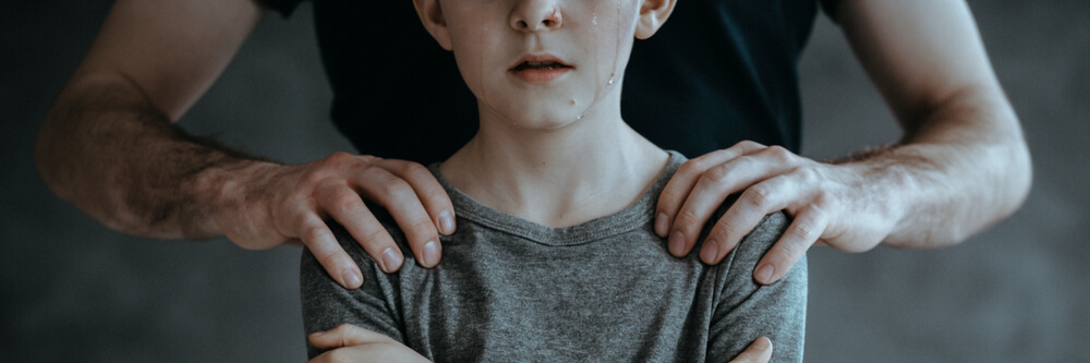 Un pédophile qui pose ses mains sur les épaules d'un garçon. 