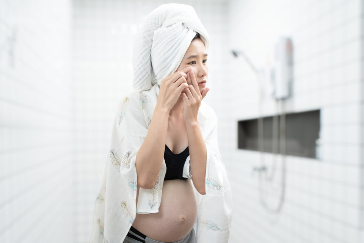Une femme enceinte qui se regarde dans le miroir. 