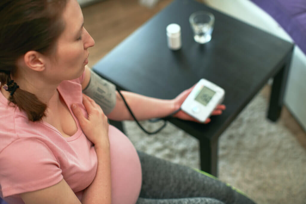 Een zwangere vrouw meet haar bloeddruk