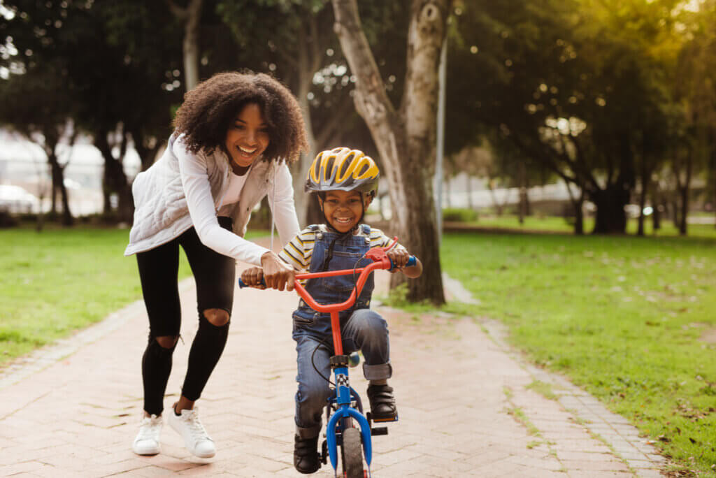 A mother teaching her child to ride a bike.