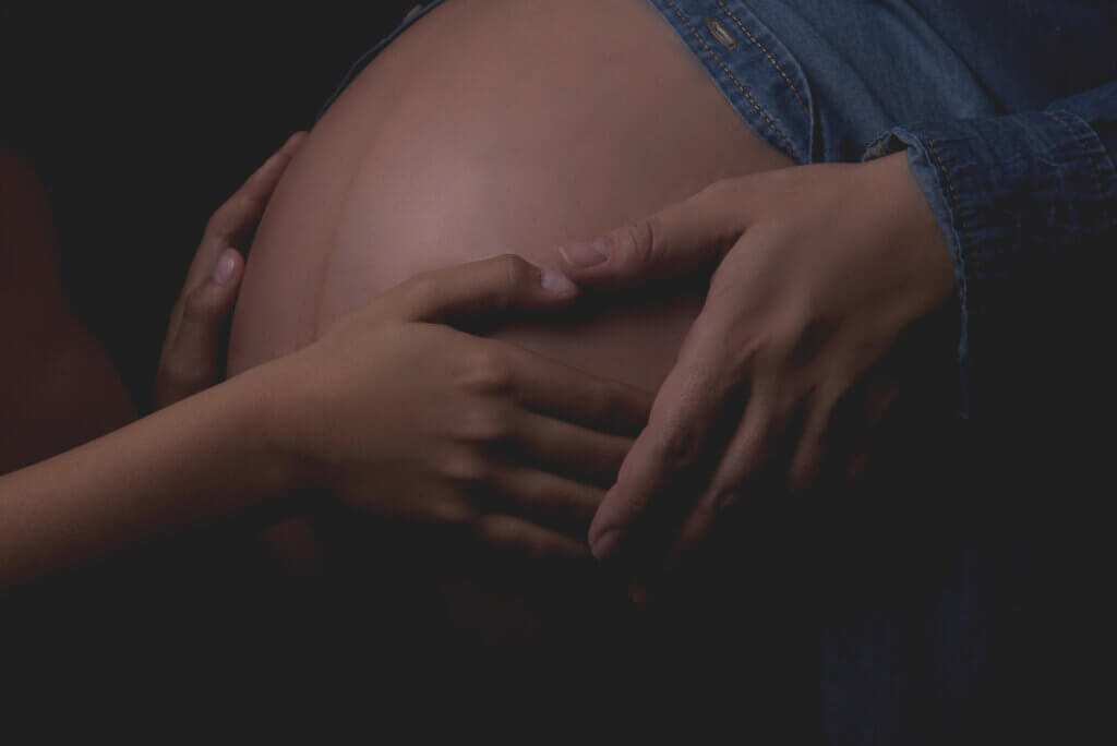 Handen op de linea alba bij zwangere vrouw