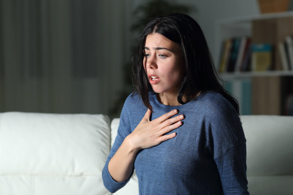 Mujer con ansiedad practicando respiración profunda.