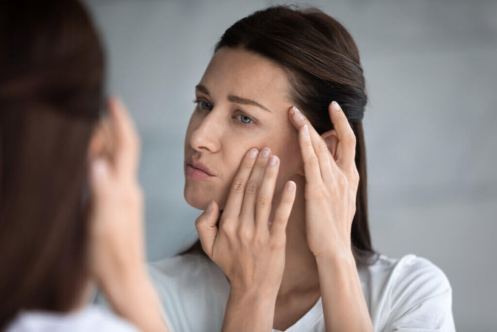 Mujer revisa su rostro por falta de colágeno.
