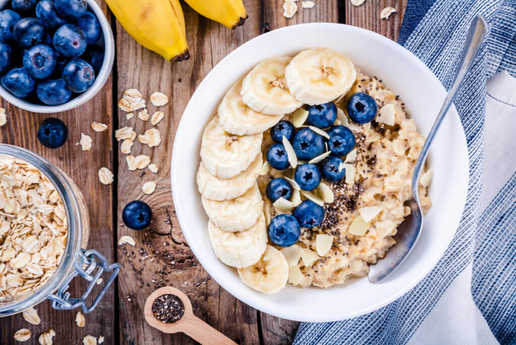 A bowl of oatmeal, nuts, chia, blueberries, and banana.