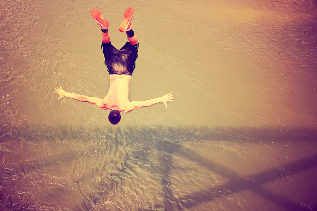A man free falling into a body of water.