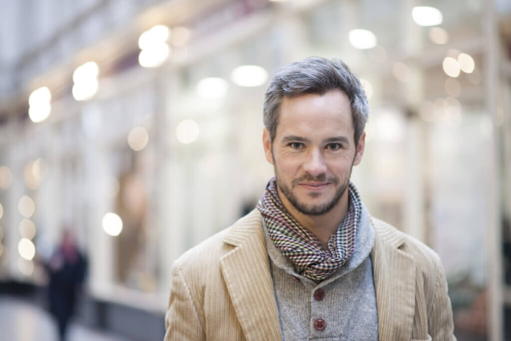 Hombre joven al que le salen canas.