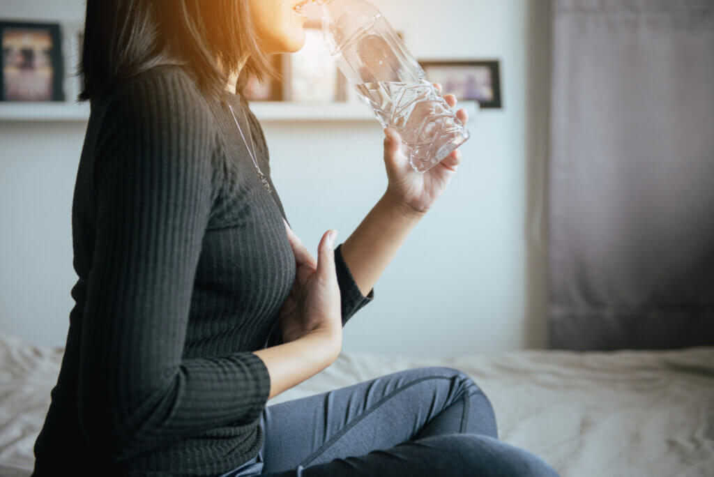 Mujer toma agua para la gastritis.
