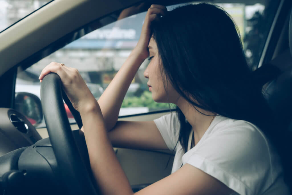 A woman driving while experiencing mental exhaustion.