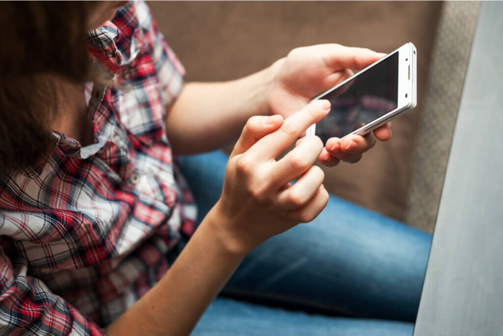 Mujer realiza búsqueda en su teléfono.