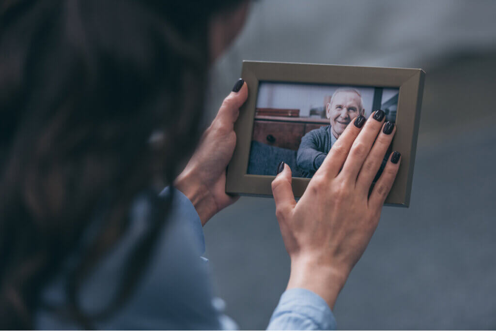Mujer hace duelo mirando un retrato.