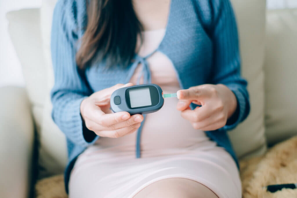 Mujer con diabetes gestacional mide su glucemia.