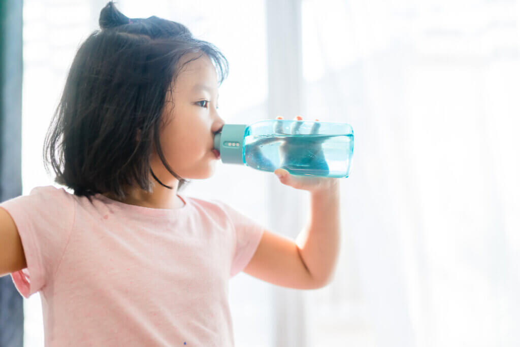 Niño con diabetes tipo 1 bebe agua.