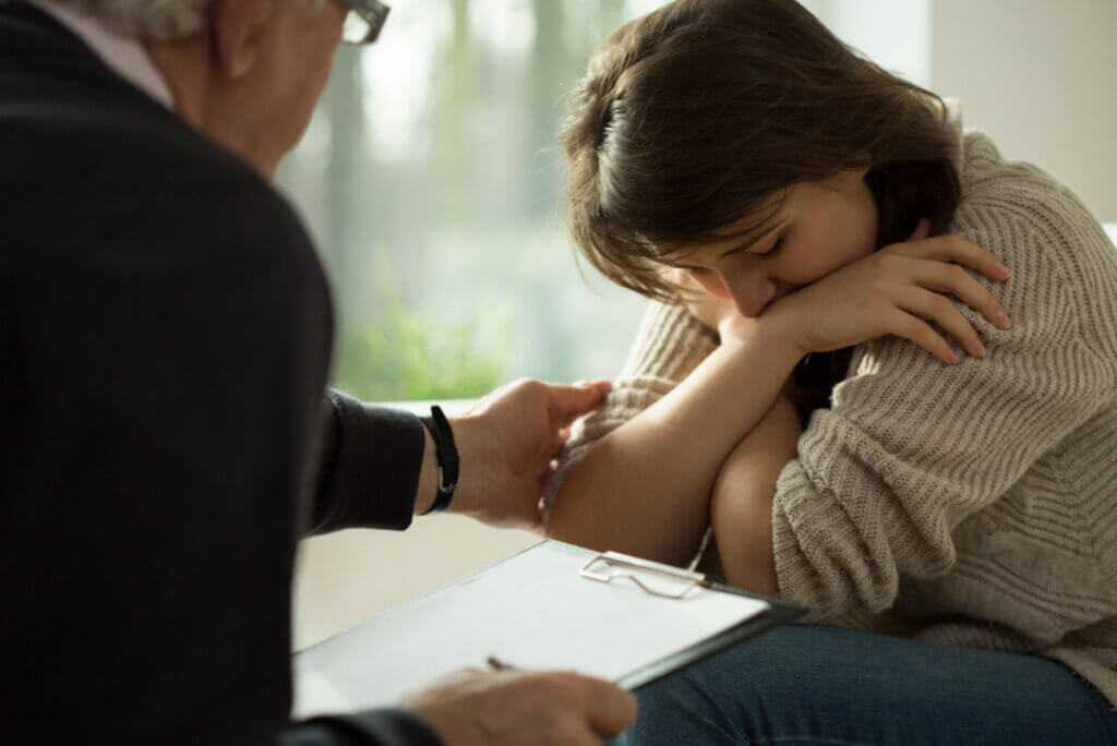 Terapeuta conforta a una mujer en la terapia psicológica.