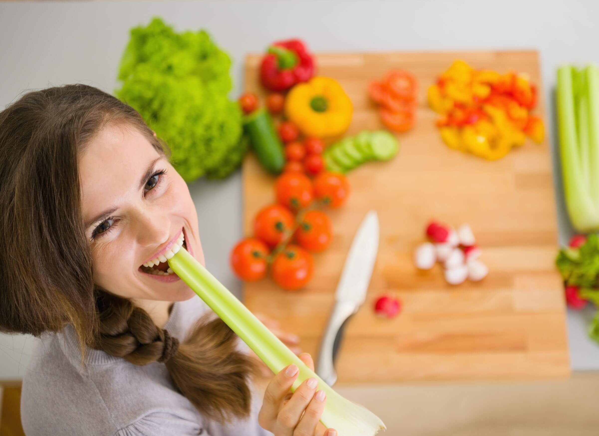 Une femme qui mange des légumes crus. 