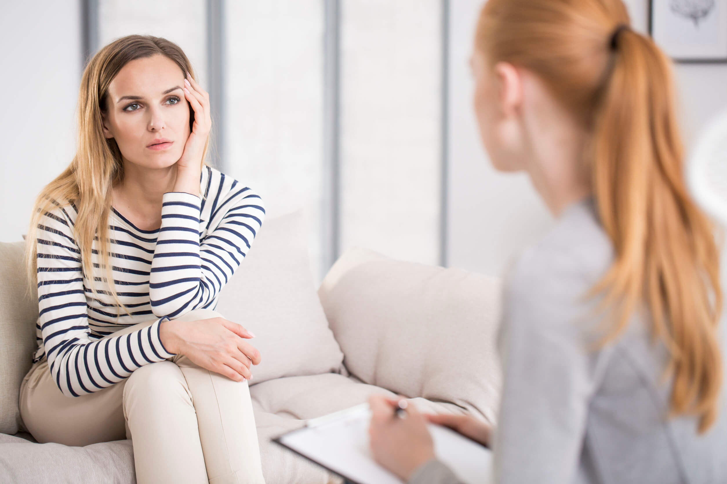 A depressed woman talking with a therapist.