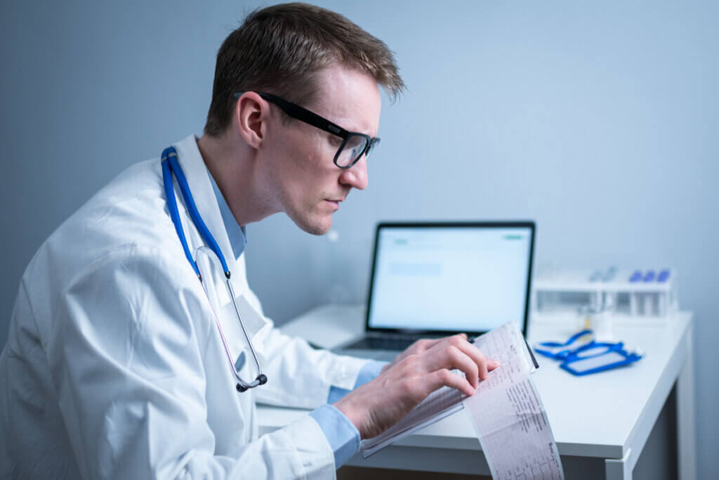 Médico revisa electrocardiograma.