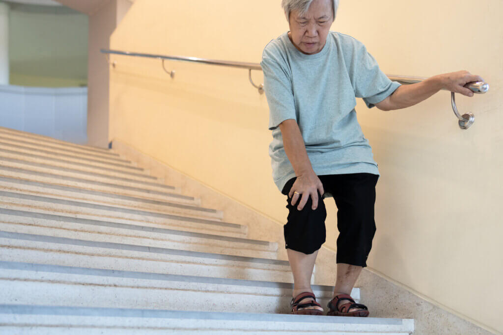 Woman with arthritis descends stairs.