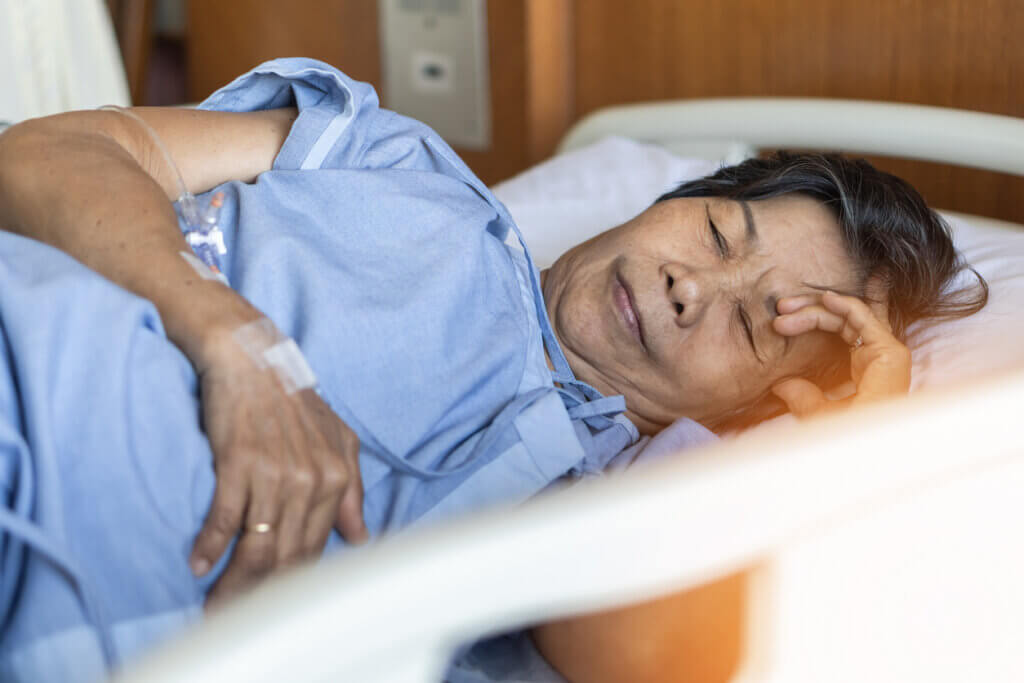 Une femme qui se repose dans un lit d'hôpital. 