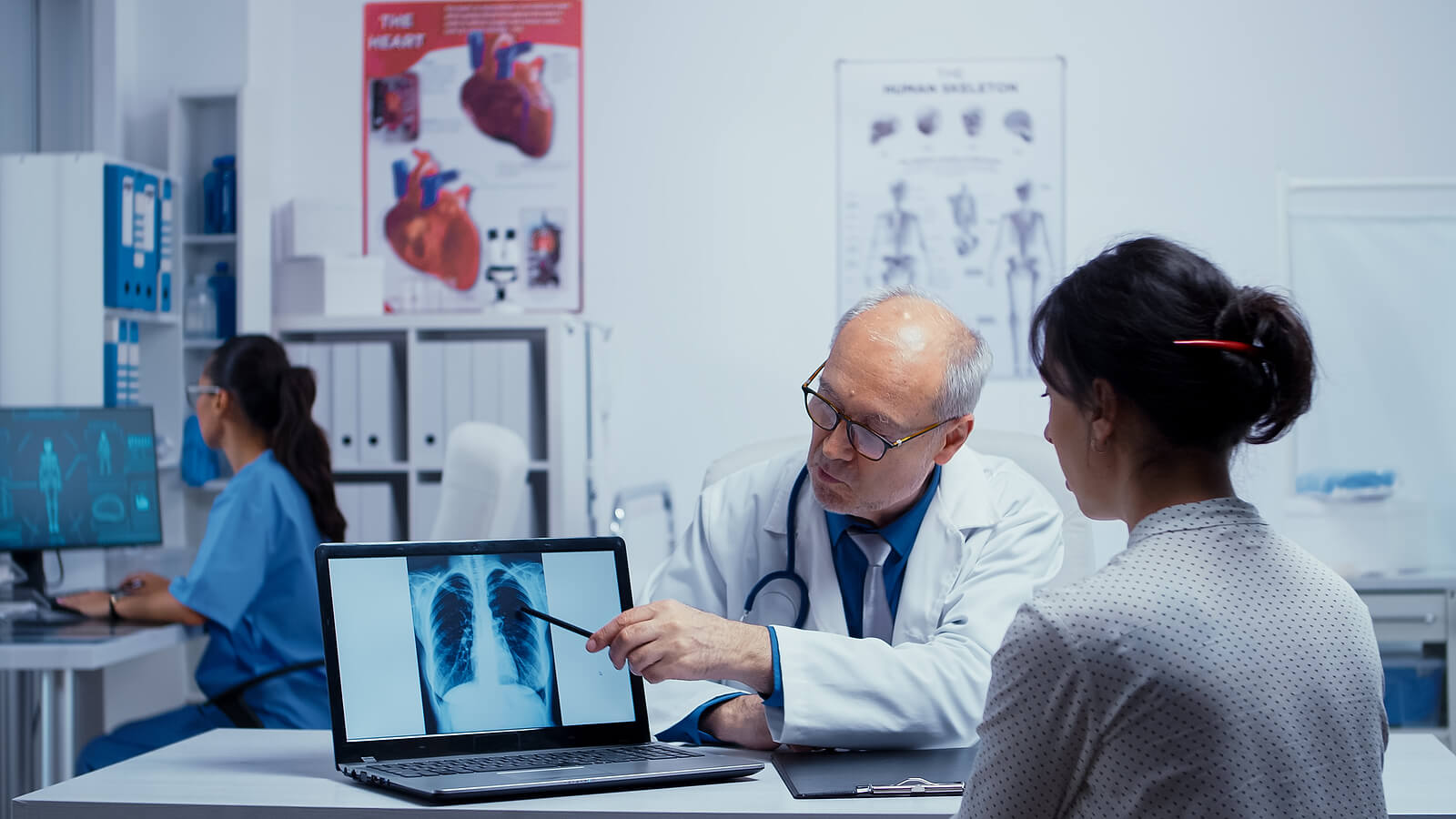Un médecin qui décrit la radiographie des poumons à une patiente. 