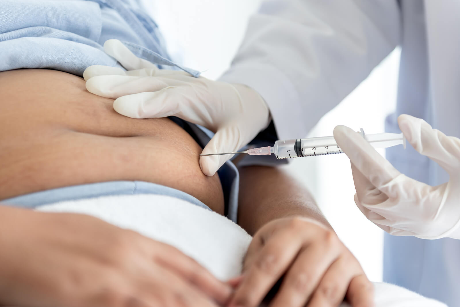 A diabetic patient receiving an insulin shot in the stomach.