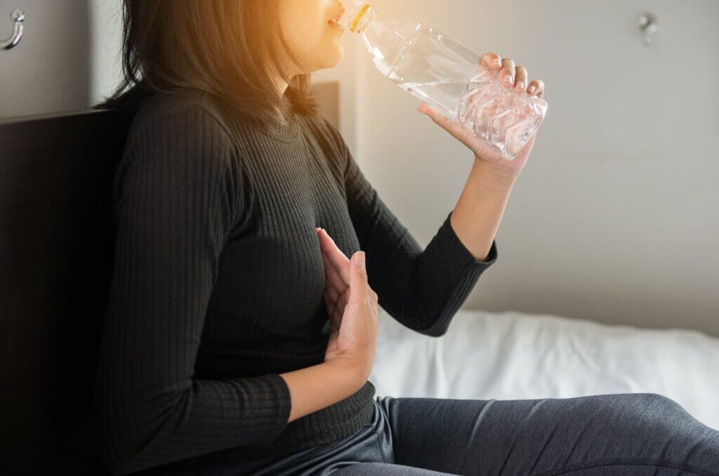 Une femme qui boit de l'eau à la bouteille. 