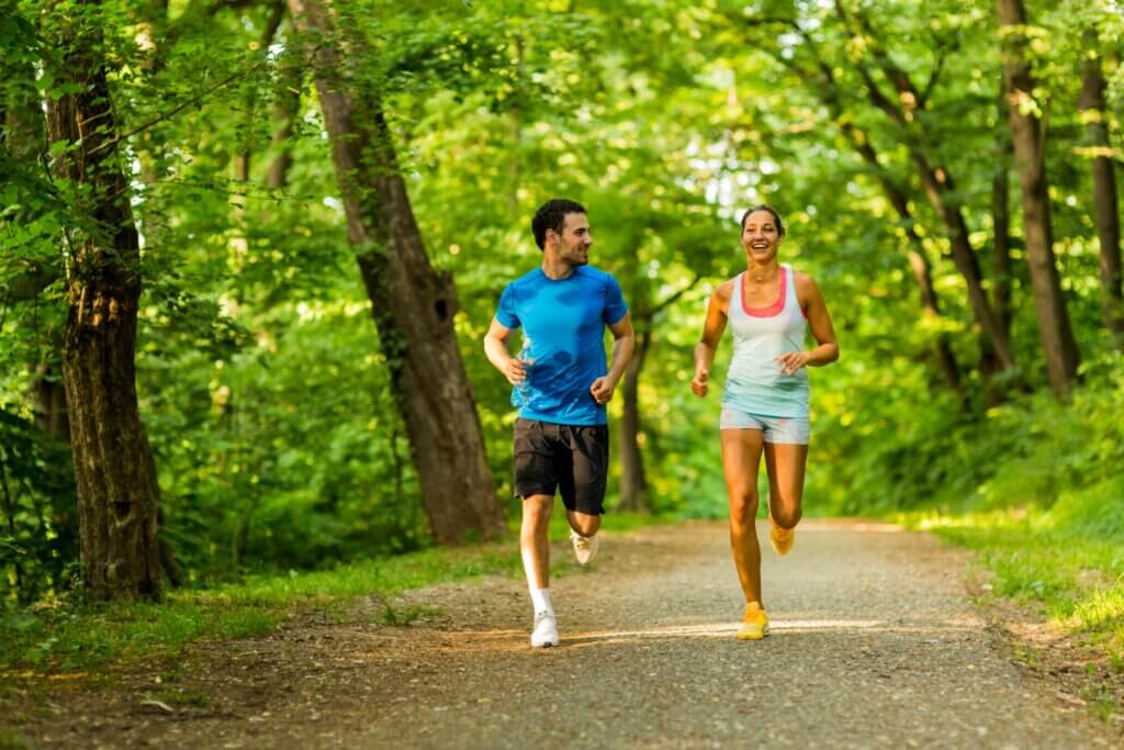 Un couple qui court en forêt.