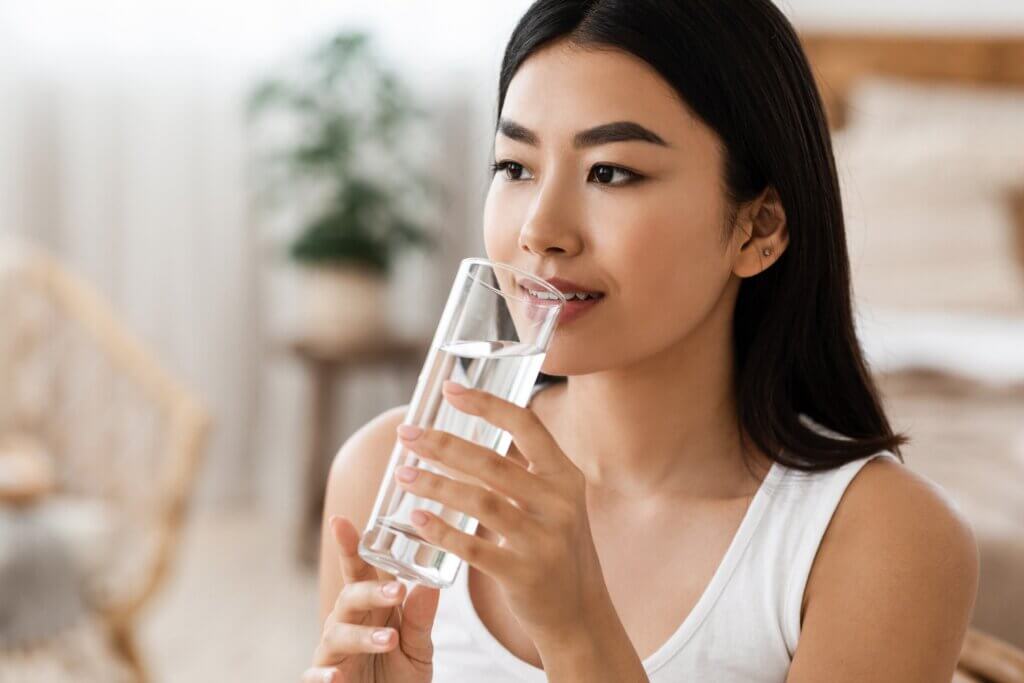 Une femme qui boit un verre d'eau. 