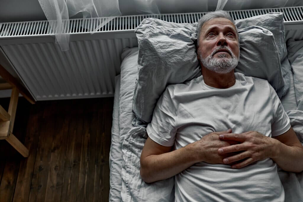Un homme âgé allongé dans un lit;