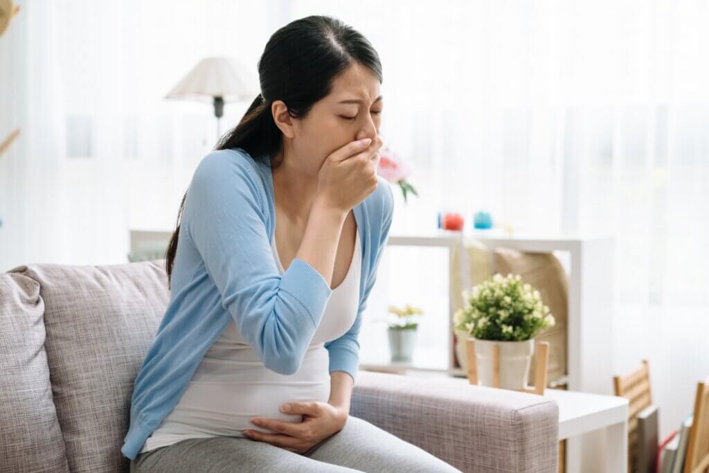 Une femme enceinte qui a envie de vomir. 