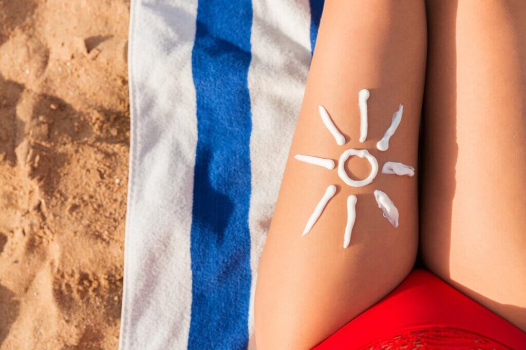 Un soleil dessiné avec de la crème sur une jambe. 