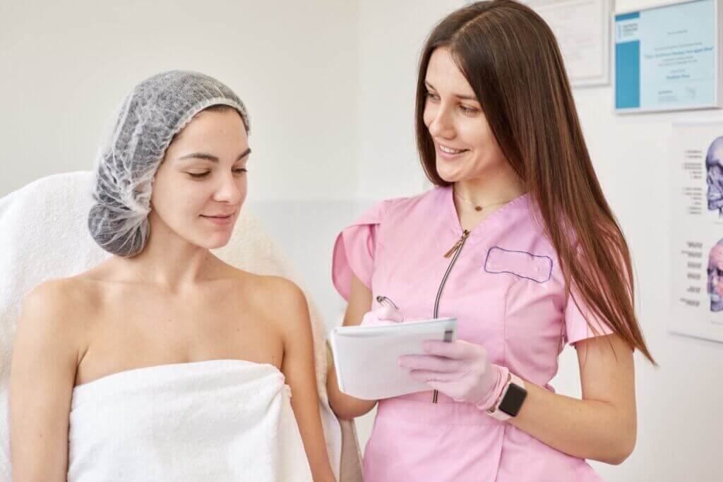 A woman talking to a nurse prior to surgery.