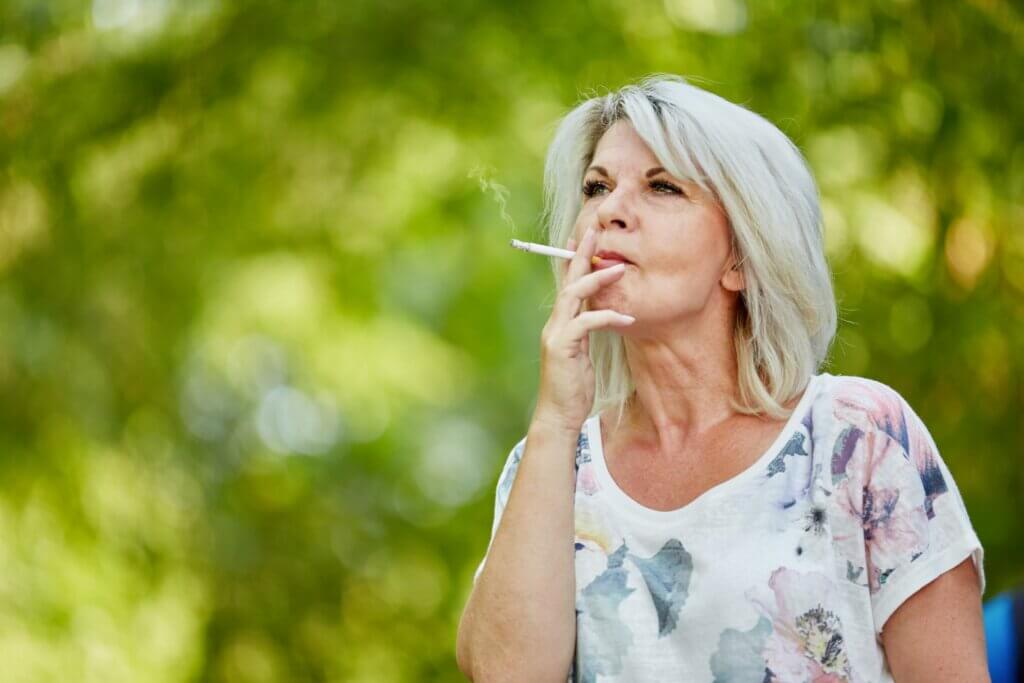 An older woman smoking a cigarette.
